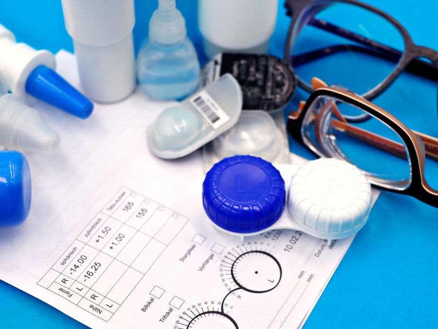 Contact lenses, case and prescription form laid out for fitting